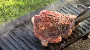 Cooking a T-bone steak on a griddle