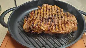 Cooking T-bone steak on a griddle